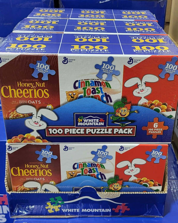 A display of six mini cereal-themed jigsaw puzzles, featuring colorful packaging with iconic breakfast cereals like Honey Nut Cheerios and Cinnamon Toast Crunch. Each box contains 100 puzzle pieces, showcasing playful designs and cartoon characters. The product is packaged attractively for easy viewing and selection.