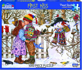A beautifully illustrated 1000-piece jigsaw puzzle titled 'First Kiss' by White Mountain Puzzles. The artwork depicts a snowy landscape with two children kissing in colorful winter attire, surrounded by a snowman and birds. The scene captures a heartwarming winter moment, ideal for family fun and nostalgia.