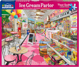 The Ice Cream Parlor jigsaw puzzle by White Mountain Puzzles features a vibrant and detailed illustration of a classic ice cream shop. The scene includes colorful decor, a clown figure, various ice cream flavors displayed behind the counter, and an array of candies and snacks. The shop is adorned with balloons and colorful signage, capturing a nostalgic and cheerful atmosphere, perfect for puzzle enthusiasts.