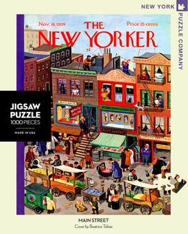 A colorful 1000-piece jigsaw puzzle titled 'Main Street' featuring an illustrated scene of a bustling street from the 1930s. The artwork includes shops like a beauty salon and a meat market, along with people engaged in various activities and vintage horse-drawn carts selling goods. The puzzle reflects a nostalgic depiction of urban life, created by Beatrice Tobias.