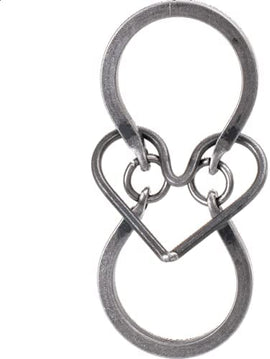 A close-up image of the Captive Heart Tavern Puzzle by Tucker Jones House. The puzzle features a unique mechanical design with intertwined loops creating an intriguing, heart-shaped visual. Made of polished metal, the puzzle is both decorative and challenging, inviting users to figure out the solution while appreciating its artistic craftsmanship.