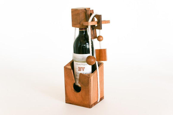 The Connoisseur's Dilemma is an intricate mechanical puzzle designed to hold a wine bottle. Crafted from rich wood, it features a series of ropes, blocks, and geometric shapes, creating an engaging challenge. Perfect for puzzle enthusiasts and wine lovers alike, this artful piece serves both as a functional wine holder and a stimulating brain teaser.