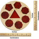 A circular wooden mechanical puzzle called Mathekreis, designed by Jean-Claude Constantin. The puzzle features eight distinct geometric shapes: a tetrahedron, pentagon, hexagon, heptahedron, octahedron, dodecahedron, and icosahedron. The shapes are outlined in black against a reddish-brown background, with each shape labeled. A triangular cutout is in the center. A measuring ruler in both inches and centimeters is placed alongside for scale.