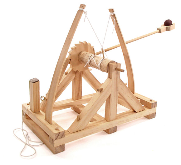 A detailed wooden model of a da Vinci catapult, featuring a large wheel, wooden base, and a mechanism for launching small projectiles. The craftsmanship highlights intricate joinery and traditional design, perfect for DIY enthusiasts and educational projects.