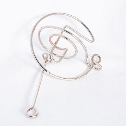 The Comet mechanical puzzle by Eureka Puzzles features a sleek, spiral design crafted from shiny metal. Its intricate twists and turns challenge users to navigate a small ball through the maze, making it a fun and engaging brain teaser for puzzle enthusiasts.