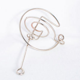 The Comet mechanical puzzle by Eureka Puzzles features a sleek, spiral design crafted from shiny metal. Its intricate twists and turns challenge users to navigate a small ball through the maze, making it a fun and engaging brain teaser for puzzle enthusiasts.