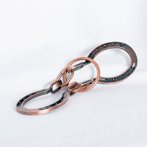 A close-up view of the Horseshoes Mechanical puzzle by Eureka Puzzles, showcasing the intricate design of interconnected metal horseshoe shapes that challenge thinkers and puzzle enthusiasts. The puzzle features a combination of shiny and brushed metal finishes, enhancing its visual appeal and complexity, ideal for those who enjoy mechanical puzzles.