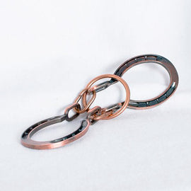 A close-up view of the Horseshoes Mechanical puzzle by Eureka Puzzles, showcasing the intricate design of interconnected metal horseshoe shapes that challenge thinkers and puzzle enthusiasts. The puzzle features a combination of shiny and brushed metal finishes, enhancing its visual appeal and complexity, ideal for those who enjoy mechanical puzzles.