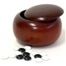 A set of two wooden Go bowls, one slightly open showing a smooth, polished surface. A collection of black and white Go stones scattered around the bowls, exemplifying elegance and functionality in gaming.