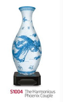 The Harmonious Phoenix Couple 3D jigsaw puzzle vase by Pintoo showcases an elegantly designed ceramic vase featuring a blue and white phoenix motif. This intricate 3D puzzle offers a unique blend of art and engaging activity, making it a perfect decorative piece once completed. The vase is displayed on a black base, enhancing its visual appeal.