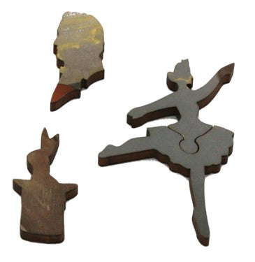 A close-up view of three intricately shaped wooden jigsaw puzzle pieces from the product 'Consequences of Hypnosis' by Kevin Sloan. The pieces include a silhouette of a head, a graceful dancer in mid-pose, and a figure with a raised arm, showcasing unique designs and a natural wood finish.