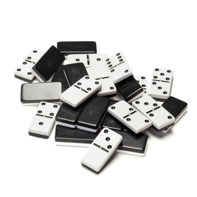 A collection of black and white dominoes scattered on a surface, showcasing various dot patterns. The dominoes feature a classic design, ideal for family games and gatherings.