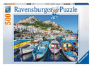 Ravensburger Colorful Marina jigsaw puzzle featuring a vibrant port scene with beautifully colored boats docked in a serene harbor, surrounded by picturesque buildings and mountains in the background. The puzzle contains 500 pieces, enriching your leisure time with a captivating image.