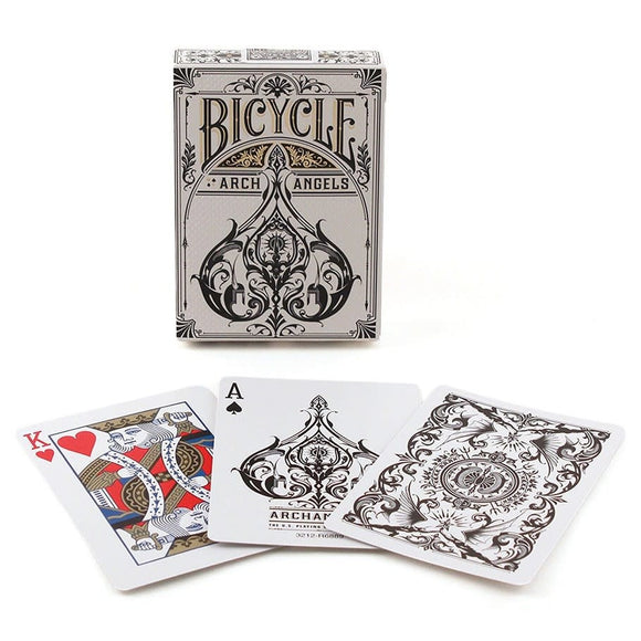 A Bicycle Arch Angels Card Deck featuring an ornate design on the box, with three playing cards displayed in front. The cards showcase intricate illustrations including a King of Hearts, an Ace of Spades with an elaborate design, and a decorated back featuring elegant patterns. The deck is produced by the US Playing Card Co., ideal for card games and collectors.