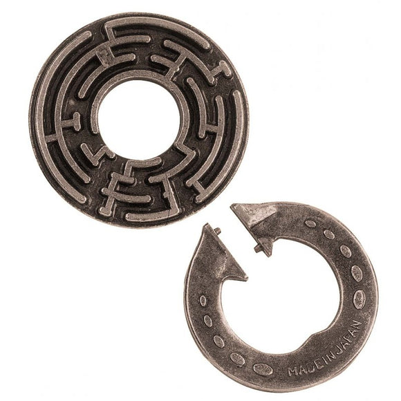The Cast Labyrinth by Hanayama is a mechanical puzzle featuring two metallic pieces. One piece is circular with a maze pattern, while the other piece is a ring with arrows indicating its movement. This elegant design encourages problem-solving and critical thinking as players navigate the maze to solve the puzzle.