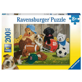 A colorful Jigsaw puzzle titled 'Let's Play Ball!' by Ravensburger. The image depicts a cheerful scene with various playful puppies engaging with sports equipment such as a football, a soccer ball, and a baseball hat. The background features a wooden fence and blooming flowers, creating a fun and vibrant atmosphere perfect for pet lovers and puzzle enthusiasts.
