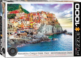 Eurographics jigsaw puzzle featuring a picturesque scene of Manarola in Cinque Terre, Italy. The image showcases colorful coastal houses perched on cliffs overlooking the clear blue Mediterranean sea and rocky shores, perfect for puzzle enthusiasts.
