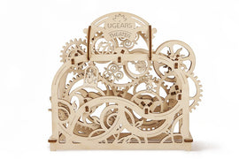 The UGears 3D Theater DIY kit features intricate wooden gears and mechanisms, creating a captivating visual representation of a theater. The design includes various gears, cogs, and a theatrical motif, showcasing its mechanical charm. Ideal for hobbyists, this kit promises an engaging build experience and an artistic display piece.