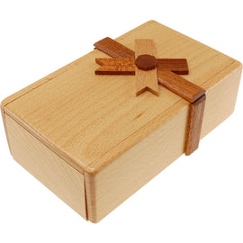The Secret Opening Box 3 by Puzzle Master is a beautifully crafted mechanical puzzle box made from high-quality wood. It features a charming design resembling a gift box, complete with a wooden ribbon and bow detailing. The light-colored wood has a smooth finish, and the box is compact and sturdy, perfect for engaging puzzles or hiding small treasures inside. Its intricate locking mechanism adds an exciting challenge for puzzle enthusiasts seeking to unlock its secrets.