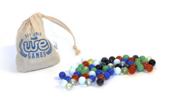 A canvas bag with 'WE GAMES' printed on it, partially open with a variety of 60 colorful marbles spilling out. The marbles are in different colors including red, blue, green, clear, and more. The arrangement showcases their glossy finish and unique designs, promoting a classic gaming experience.