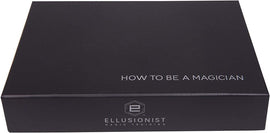 The 'How To Be A Magician' boxset by US Playing Card Co. features a sleek black exterior with the title printed in white letters. The Ellusionist logo is visible at the bottom, representing quality magic training resources for aspiring magicians.