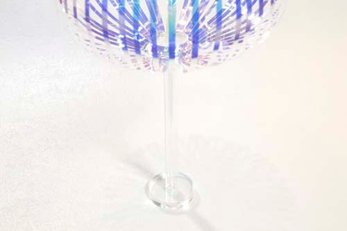 The Prodia Rainbow Stick Stand features a vibrant, multi-colored design with a transparent base. The stand is crafted to hold various items elegantly, showcasing its unique rainbow pattern that enhances any decor.