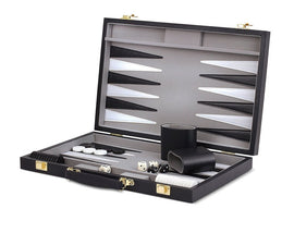 A stylish 15-inch black backgammon set by Wood Expressions Inc. The set is open, showcasing a smooth interior with black and white checker pieces, dice, and a comfortable wrist rest. The box features a sturdy design with gold fittings and ample storage for game components.