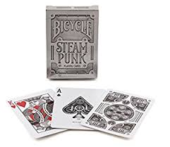 Bicycle Steampunk playing cards featuring intricately designed cards. The deck showcases a stylish silver-themed box with detailed artwork, and three displayed cards highlighting unique designs, including the Ace of Spades and King of Hearts.