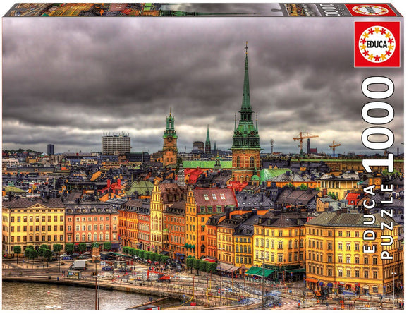 Educa jigsaw puzzle titled 'Views of Stockholm, Sweden' featuring a colorful and detailed aerial view of Stockholm’s architecture, with towers and rooftops under a cloudy sky. The puzzle has 1000 pieces and is designed for adults and older children. Its vibrant imagery showcases the historical buildings and modern elements of the cityscape.