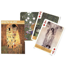 A beautifully designed set of playing cards featuring artwork by Gustav Klimt. The packaging showcases one of Klimt's famous paintings, while the visible cards display artistic designs, including floral patterns and iconic images like 'The Kiss.'