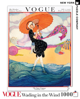 A 1000-piece jigsaw puzzle featuring an artistic illustration from a July 1919 Vogue magazine cover. It shows a woman in a stylish black dress holding a parasol, standing on the beach beside colorful umbrellas, with waves and clouds in the background. The vibrant colors and design evoke a sense of nostalgia for vintage fashion.