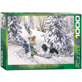 The box of the jigsaw puzzle titled 'It's Your Turn' by Eurographics, featuring an illustration by Douglas R. Laird. The scene shows children and dogs playing in a snowy landscape, with sleds and a backdrop of evergreen trees and a distant house. The puzzle contains 1000 pieces, ideal for family fun and relaxation.