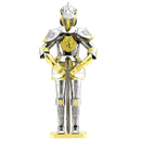 A detailed model of a European armor knight constructed from metal sheets. The knight features a shiny silver finish with intricate gold accents on its armor. It holds a sword and stands on a base, showcasing the craftsmanship and design typical of historical knights.