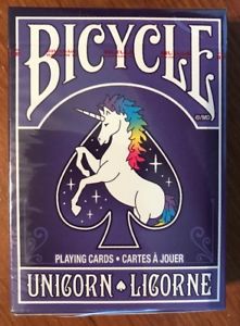 Bicycle Unicorn Playing Cards featuring a whimsical unicorn illustration set against a purple background. The card box displays vibrant colors and elegant typography, perfect for both casual and serious card players who love unique designs.