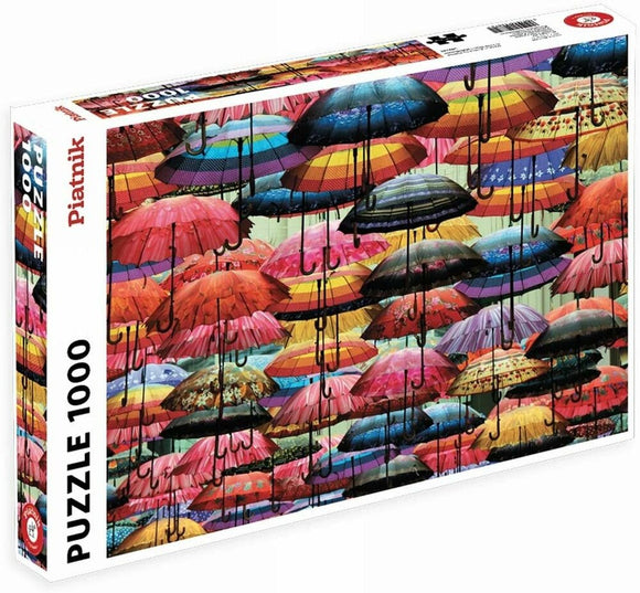 The Piatnick 1000-piece jigsaw puzzle titled 'Umbrellas' features a vibrant collage of colorful umbrellas, showcasing various designs and patterns. The puzzle box is prominently displayed, with a clear view of the stunning umbrella artwork, inviting puzzle enthusiasts to assemble the lively scene.