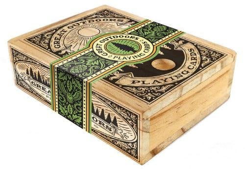 The Great Outdoors Playing Cards box features a beautifully designed, rustic exterior with intricate nature-themed illustrations and a central round cut-out. The lid is adorned with the text 'Great Outdoors Playing Cards' in vintage typography, surrounded by green accents and images of trees, creating an inviting look for outdoor enthusiasts and card game lovers alike.