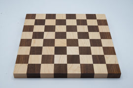 A beautifully crafted 12 inch chessboard featuring 1.5 inch squares, made from high-quality wood. The board has an alternating pattern of light and dark squares, perfect for an engaging game of chess.