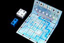 Railroad Ink: Deep Blue Edition game components, featuring a colorful game board with blue tracks and paths, two sets of dice for gameplay, and a scoring area on the side. The design showcases a fun, strategic game experience suitable for family and friends alike.