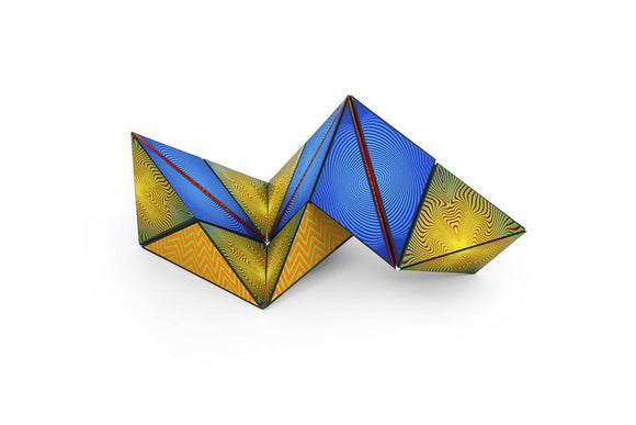 Shashibo Optical Illusion puzzle by Geobenders, featuring a vibrant design with multi-colored geometric patterns. The mechanical puzzle can be transformed into over 70 shapes, challenging users to explore optical illusions through tactile play.