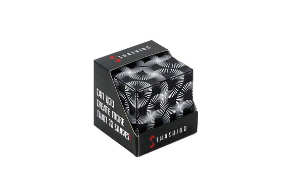 Shashibo Black & White box showing intricate black and white designs, featuring the question 'Can you create more than 70 shapes?' The box is sturdy and designed for multiple transformations, encouraging creativity through play.
