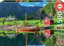 A 1500-piece jigsaw puzzle featuring a picturesque Viking ship by the waterside, surrounded by lush greenery and a traditional red house in a serene landscape.