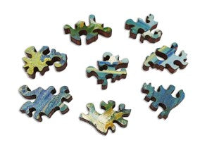 A collection of intricately shaped jigsaw puzzle pieces featuring vibrant colors and designs inspired by Van Gogh's painting 'Sea at Saint-Maries'. The pieces display a mixture of greens and blues, reminiscent of ocean waves.