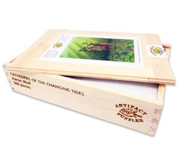 Artifact Wooden Puzzles presents 'Cathedral of the Changing Tides' by Aaron Wolf, a beautifully crafted 504-piece jigsaw puzzle. The wooden box features the puzzle artwork on the lid, showcasing a serene landscape filled with vibrant greenery and intricate details, perfect for puzzle enthusiasts and nature lovers.