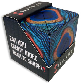 The Shashibo Wings is a mechanical puzzle by Geobenders, featuring a vibrant design reminiscent of a peacock's tail. The cube challenges users to create over 70 different shapes, promoting creativity and fine motor skills. Its colorful, abstract patterns are visually striking, inviting users to explore the various transformations possible with this unique puzzle toy.
