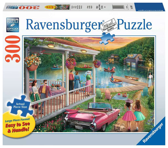 A vibrant jigsaw puzzle box titled 'Summer at the Lake' by Ravensburger, featuring a picturesque lakeside scene. The illustration shows colorful figures enjoying the summer sun, with a classic pink convertible parked nearby and scenic boats on the water. The packaging highlights 300 pieces with large, easy-to-handle formats, ensuring an enjoyable puzzling experience.
