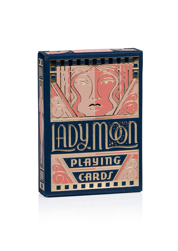 The 'Lady Moon' playing cards box from US Playing Card Co. features an elegant design with artistic illustrations on a deep blue background. The box showcases a prominent face motif and gold foil details, making it visually striking. Perfect for game nights and collectors, the cards offer a unique twist to traditional gameplay.