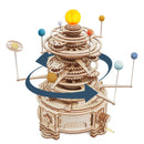 A detailed wooden model kit of the solar system, featuring rotating gears and colorful planet representations. The sun is at the top, surrounded by the planets arranged in a spiral design. The kit showcases intricate craftsmanship and a mechanical movement, perfect for educational and decorative purposes.