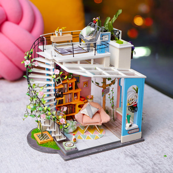 Dora's Loft DIY Model Kit by Robotime is a delightful miniature home model featuring intricate details. It showcases a spiral staircase, cozy living area with bookshelves, a soft pink chair, and vibrant plants. The scene is crafted with artistic touches and realistic furnishings, making it perfect for craft enthusiasts and model builders.