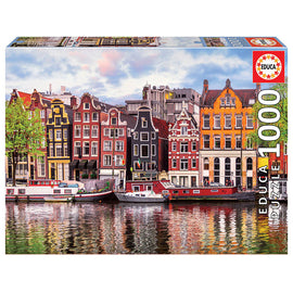 Educa 1000-piece jigsaw puzzle featuring the iconic Dancing Houses of Amsterdam, showcasing intricate details of the colorful canal-side buildings and boats reflecting in the water.