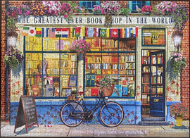 Jigsaw puzzle of a charming bookshop titled 'The Greatest Ever Book Shop in the World.' The image features a flower-adorned facade with colorful flags, a bicycle with a basket, and shelves brimming with books visible through the large windows. The entrance shows a quaint 'Open' sign, inviting visitors into the literary haven.